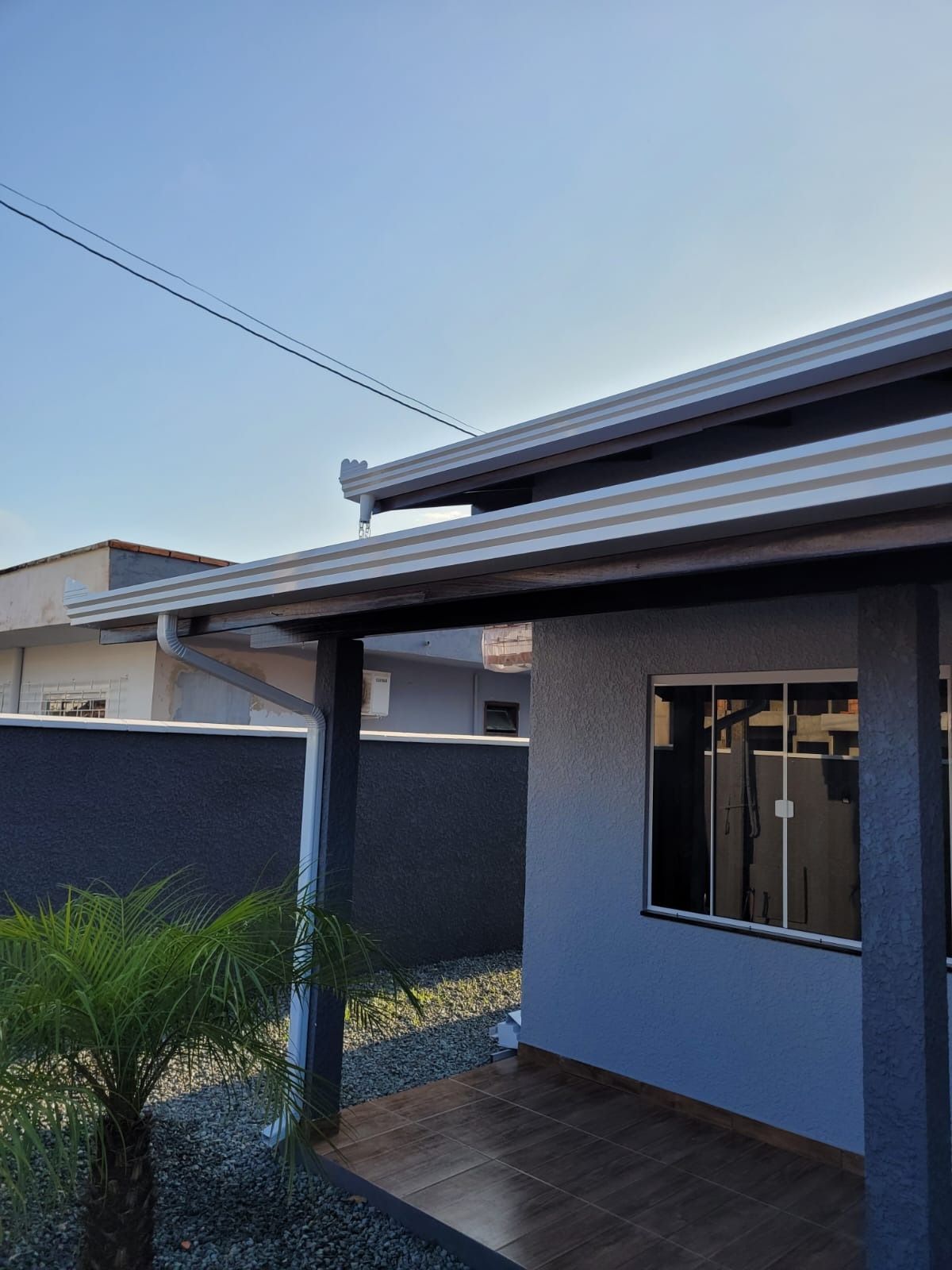 Calha de alumínio branca instalada na varanda de residência em Penha, Santa Catarina