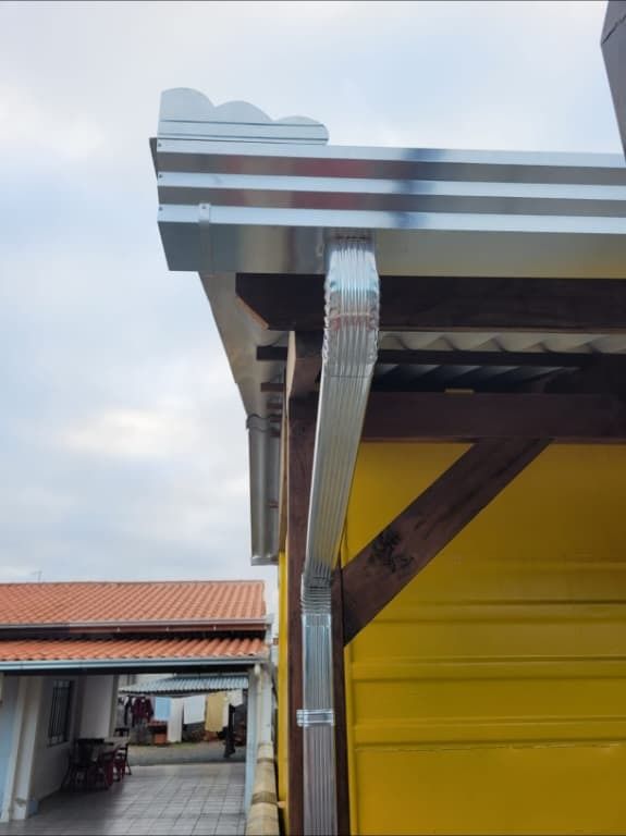 Calha e condutor galvanizado instalados em área externa em Penha, SC