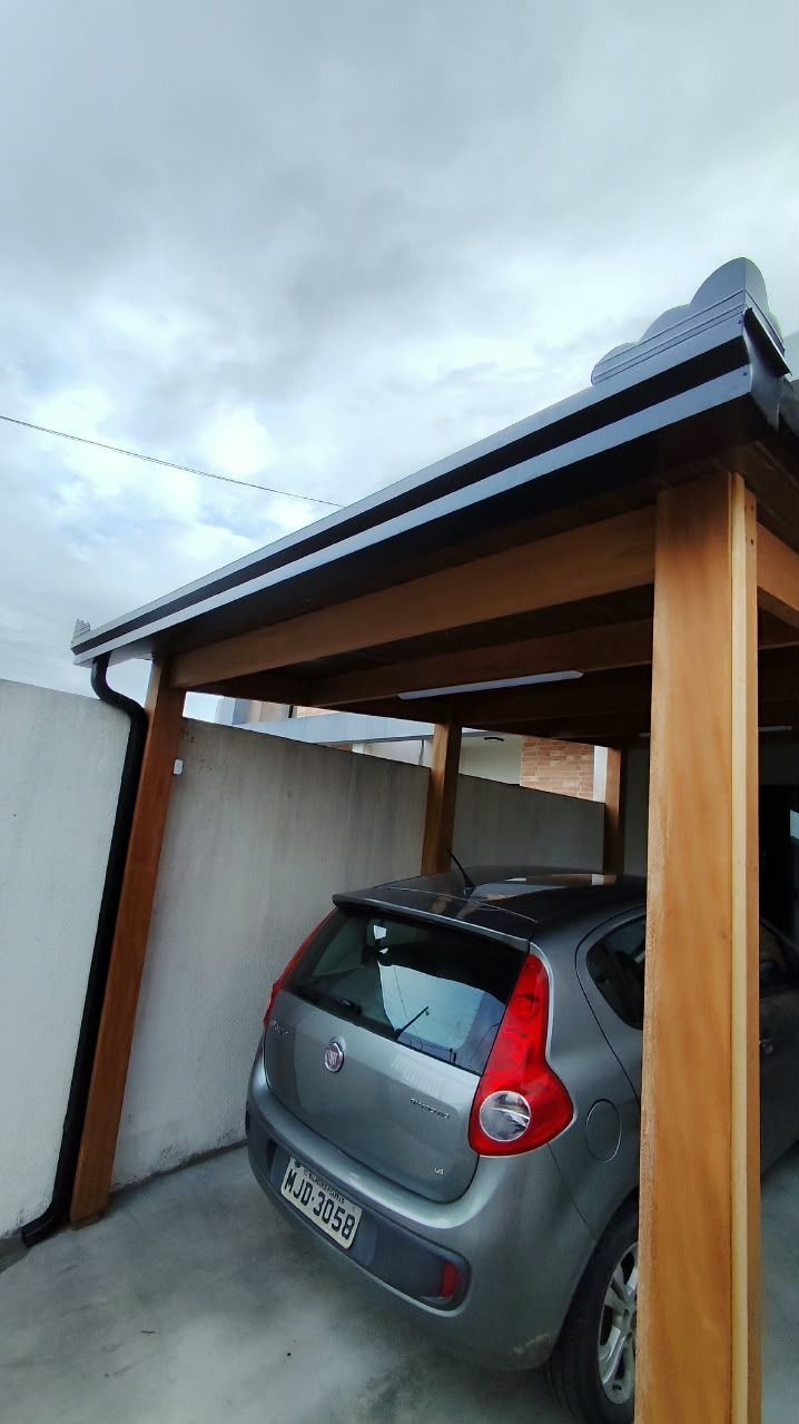 Calha preta e condutor de água instalados em garagem coberta em Penha, SC