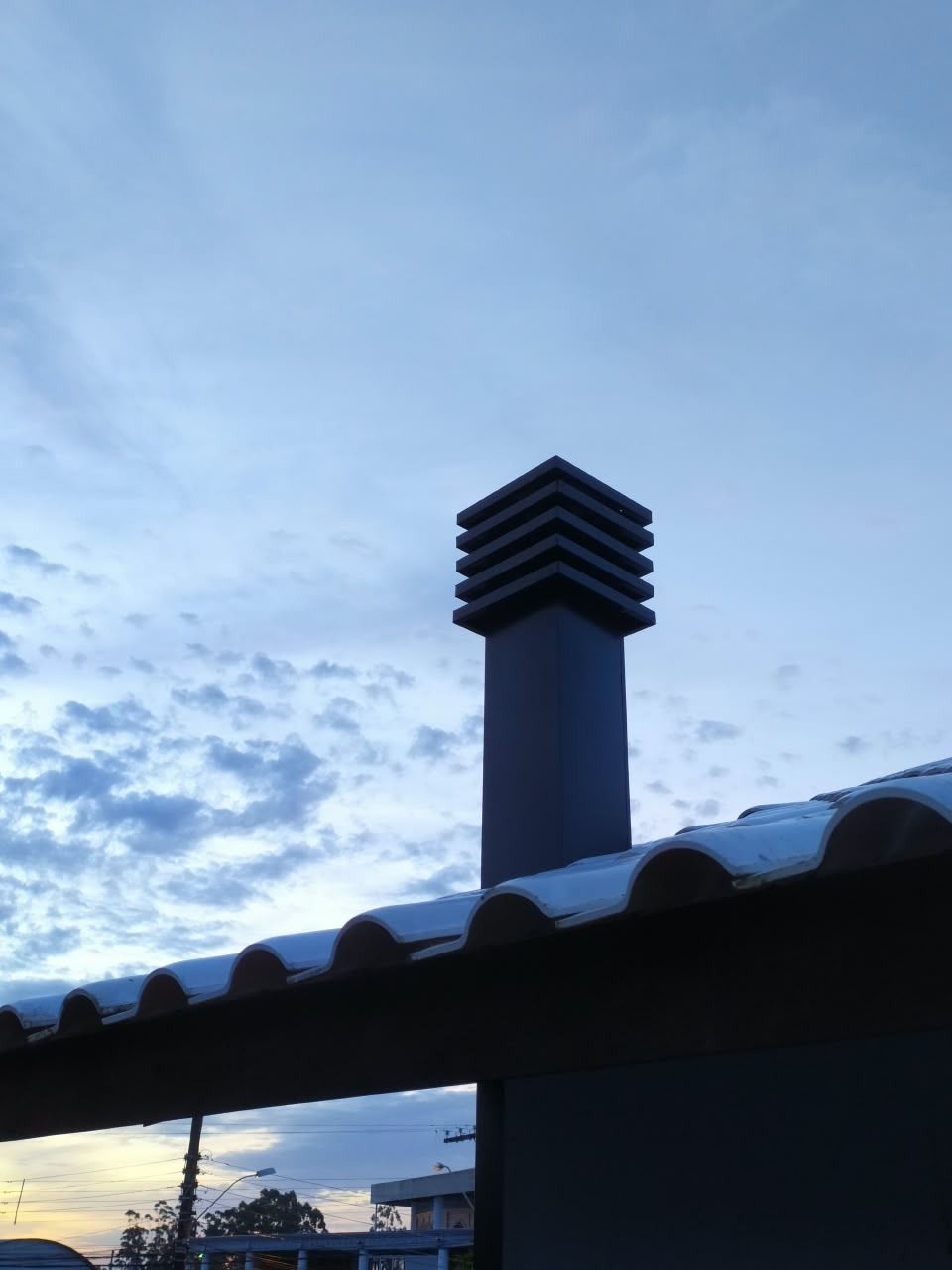 Chaminé preta com chapéu tipo lanternim instalada em telhado em Penha, Santa Catarina