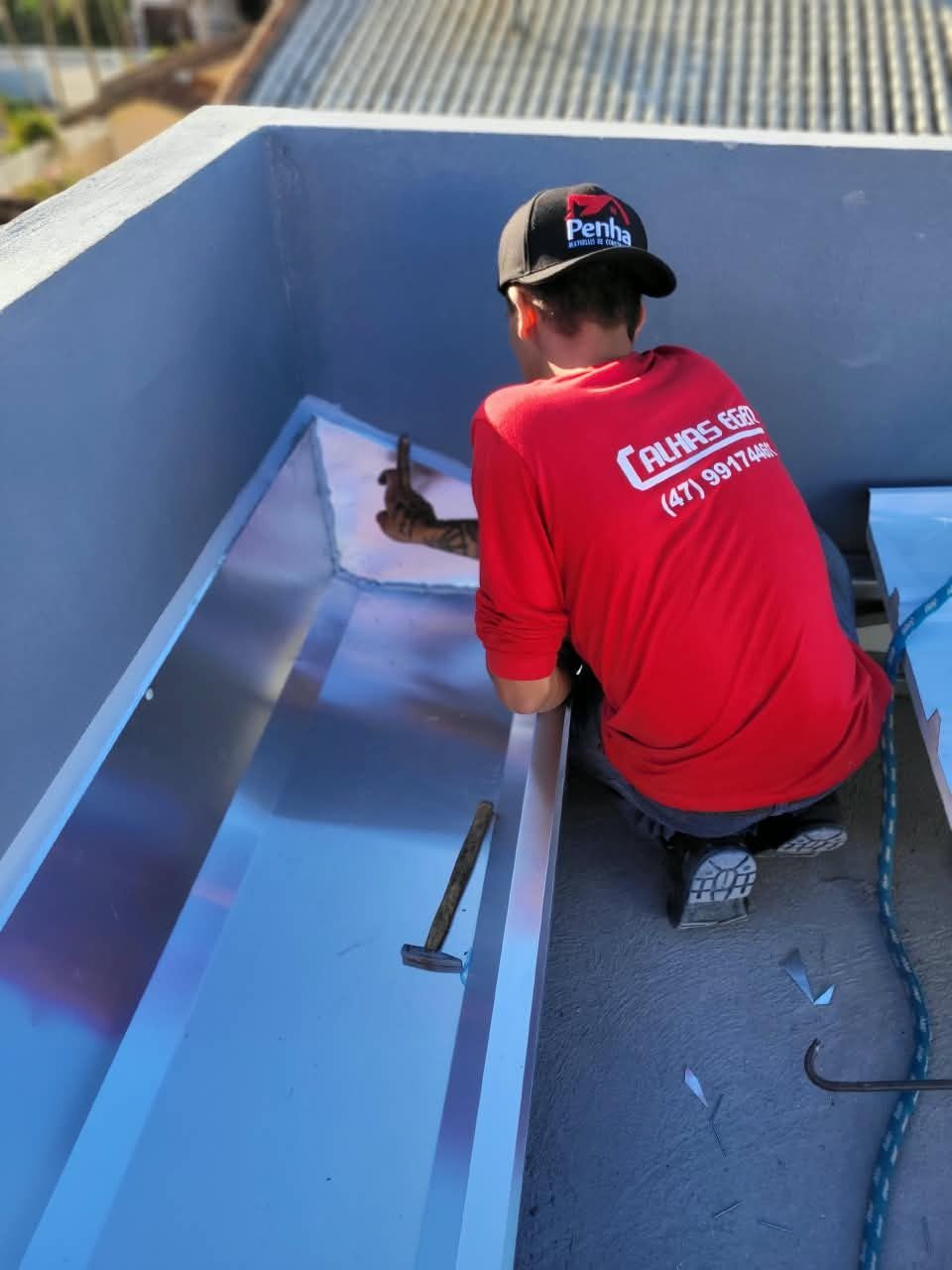 Profissional da Calhas Eger instalando rufo e calha em platibanda em Penha, SC